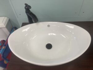 Bathroom sink drain being replaced
